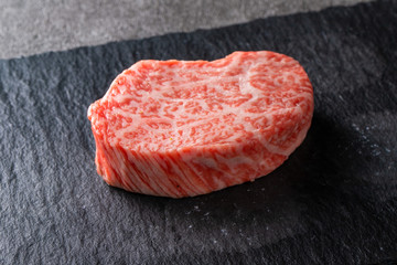 Tek porsiyon A5 Wagyu steak siyah arduvaz tabak üzerinde, yoğun mermerleşme
