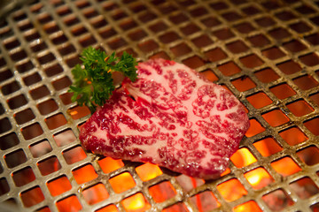 A5 Wagyu dilimi kor halindeki kömür ızgarada pişerken, yakiniku tekniği